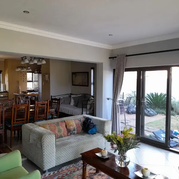 Painting job: lounge and dining area with fresh grey walls and white cornice