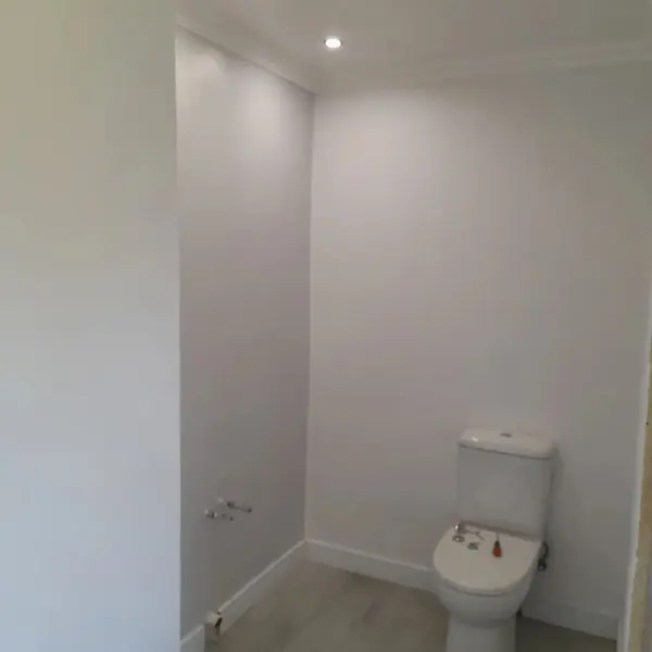 Painting job: toilet room walls and cornice freshly painted white, even finish