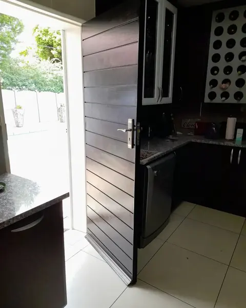 After. Painting job: dark painted door open, backlit kitchen