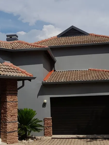 Painting job: grey house, painted gutters and roof edges, double garage