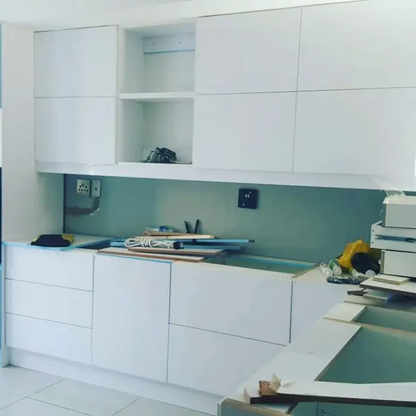Renovations job: white kitchen cabinets installed, tools and offcuts on counter