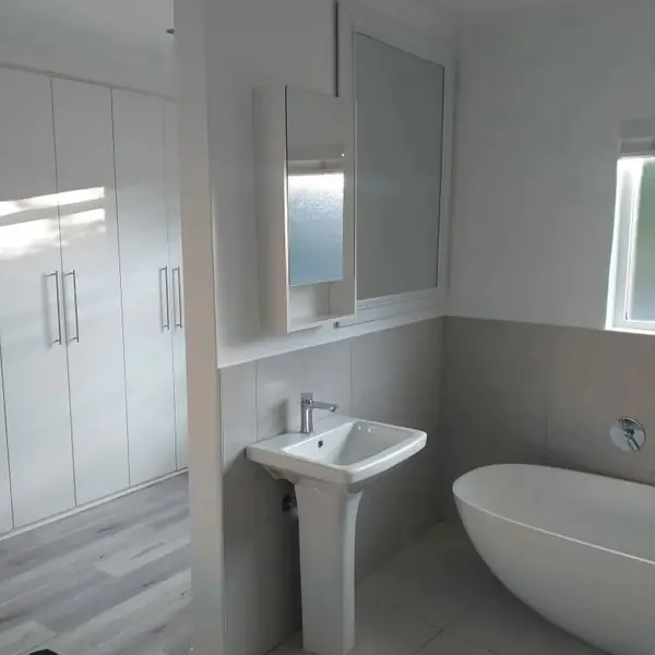 Renovations job: bathroom with freestanding bath, pedestal basin, white built-in cupboards