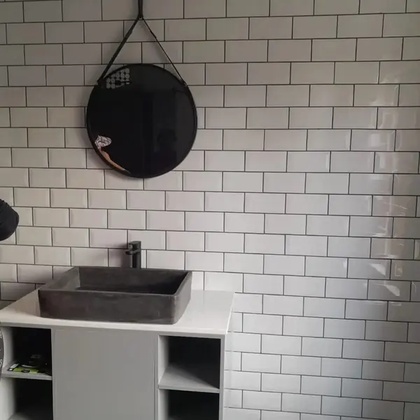 Renovations job: bathroom wall of subway tiles, concrete basin and mirror
