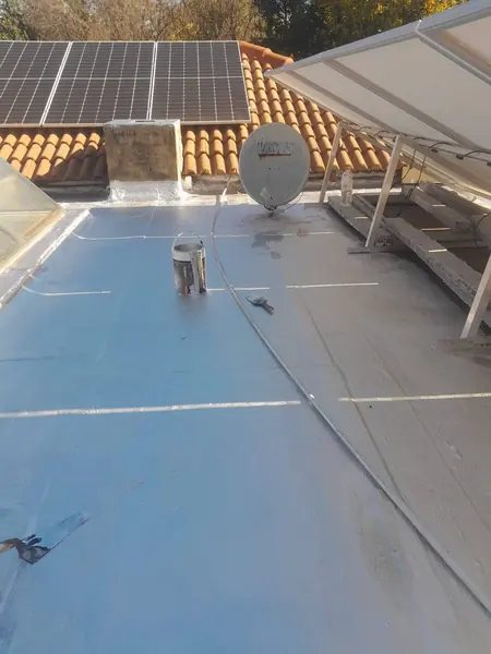 Waterproofing job: flat roof half coated, paint tin and brush visible