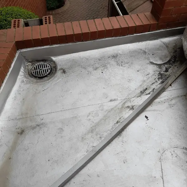 Waterproofing job: roof drain in grey membrane, dark stains visible